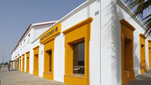 A building with yellow-framed windows and a sign that reads "HABITACIONES." - As Hotels Chucena (Chucena)