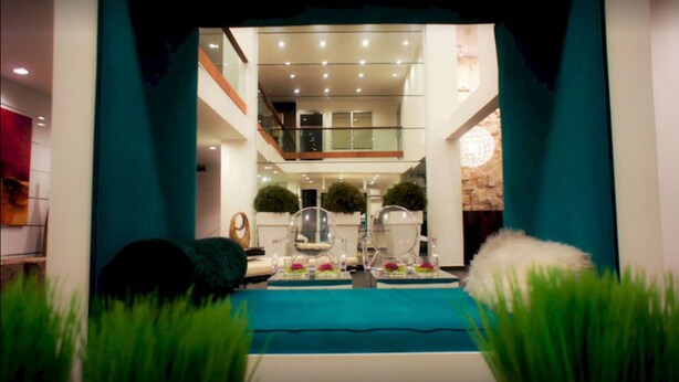 Un intérieur moderne avec un espace salon central, un escalier et une vue sur l’étage supérieur.
