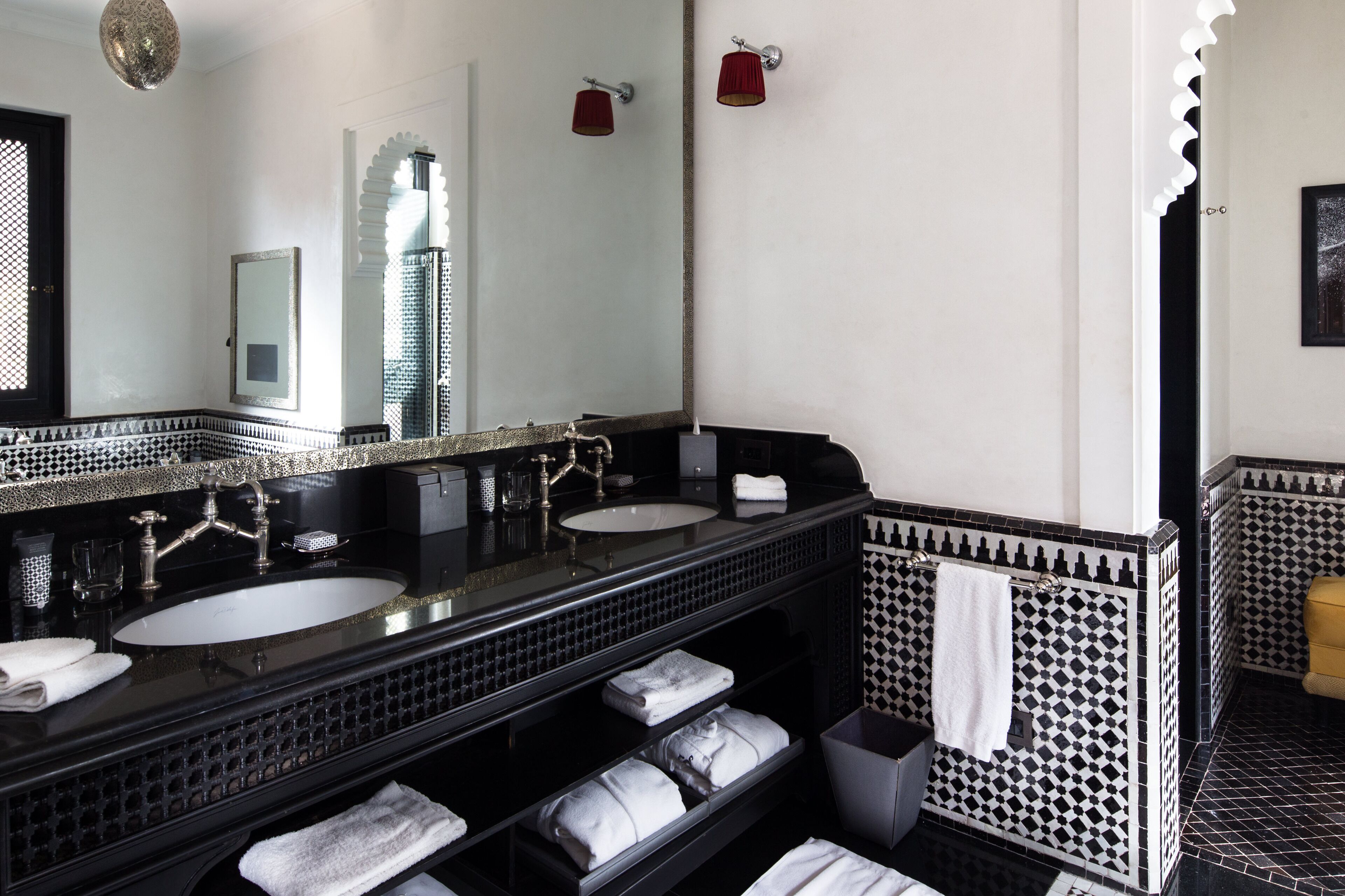 Une salle de bain avec deux lavabos, un grand miroir et un porte-serviettes.