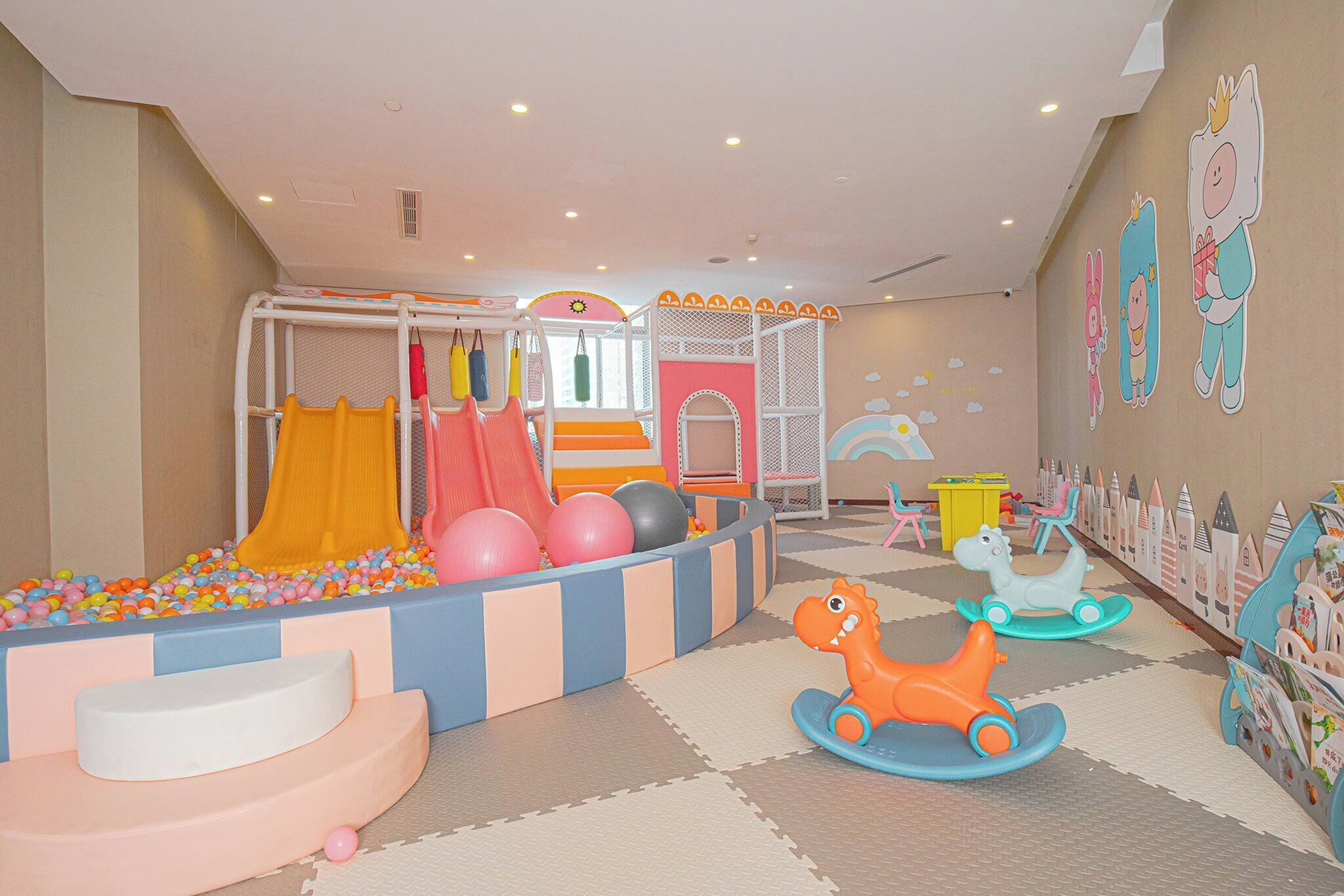 A children's play area with a slide, ball pit, and soft play structures.