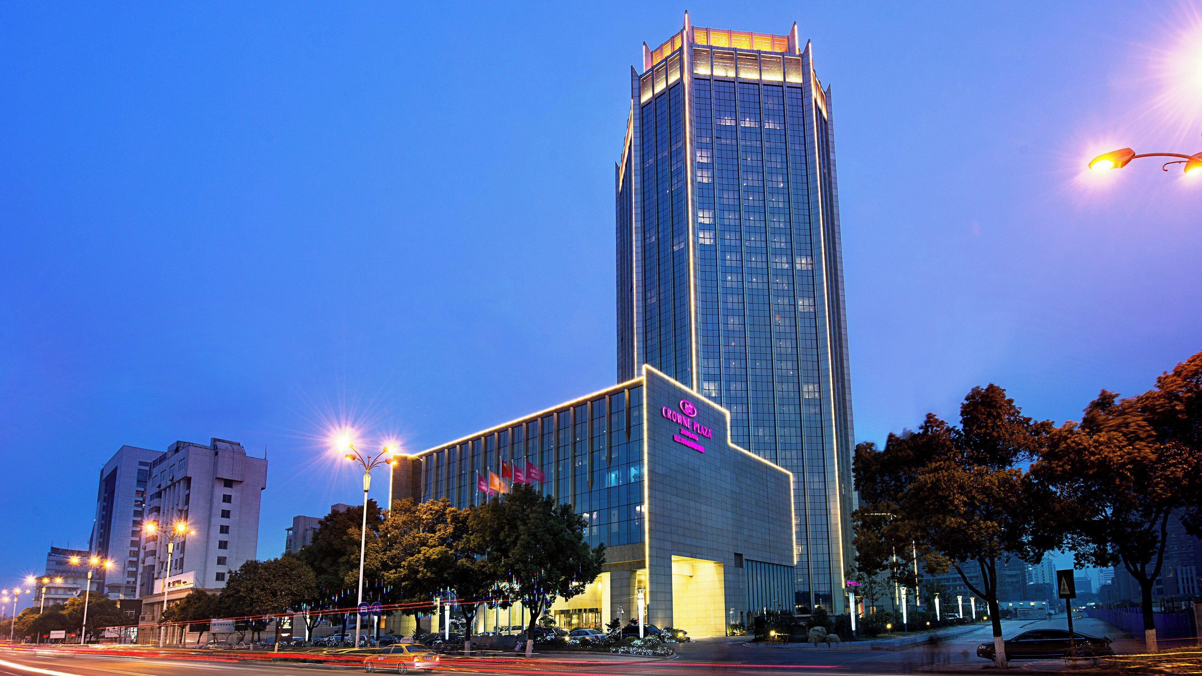 Un bâtiment moderne doté d’une façade en verre remarquable et d’une enseigne indiquant « CROWNE PLAZA ».