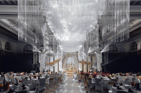 A banquet hall with tables set for a formal event, featuring a central stage and elegant floral arrangements. - Crowne Plaza Zhenjiang by IHG (Zhenjiang)