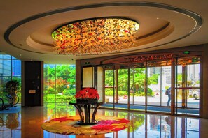 A lobby with a large glass window, a decorative ceiling, and a reflective floor. - Crowne Plaza Zhenjiang by IHG (Zhenjiang)