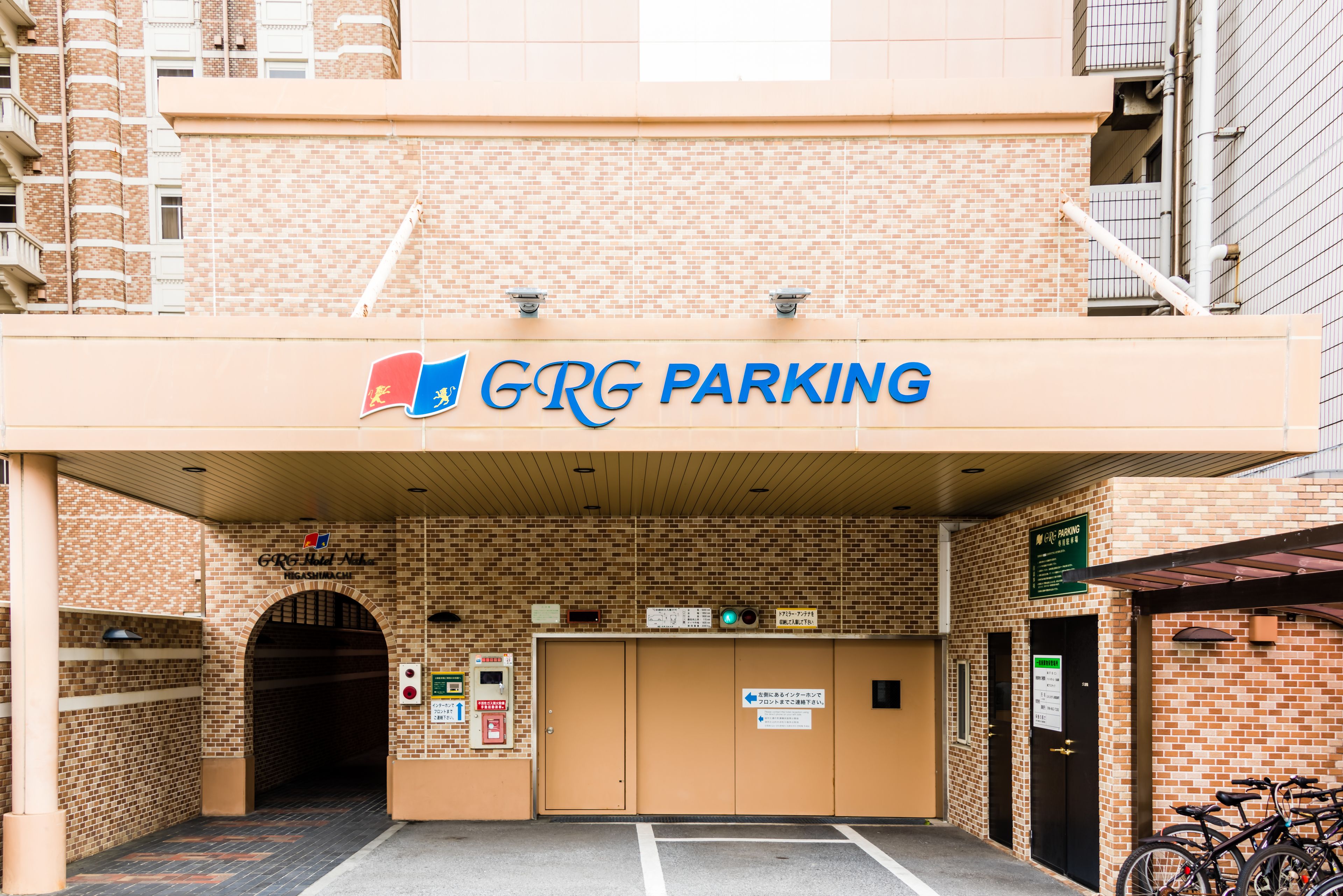A GRP parking entrance with a brick facade, a covered entrance, and a sign indicating a 24-hour service area.