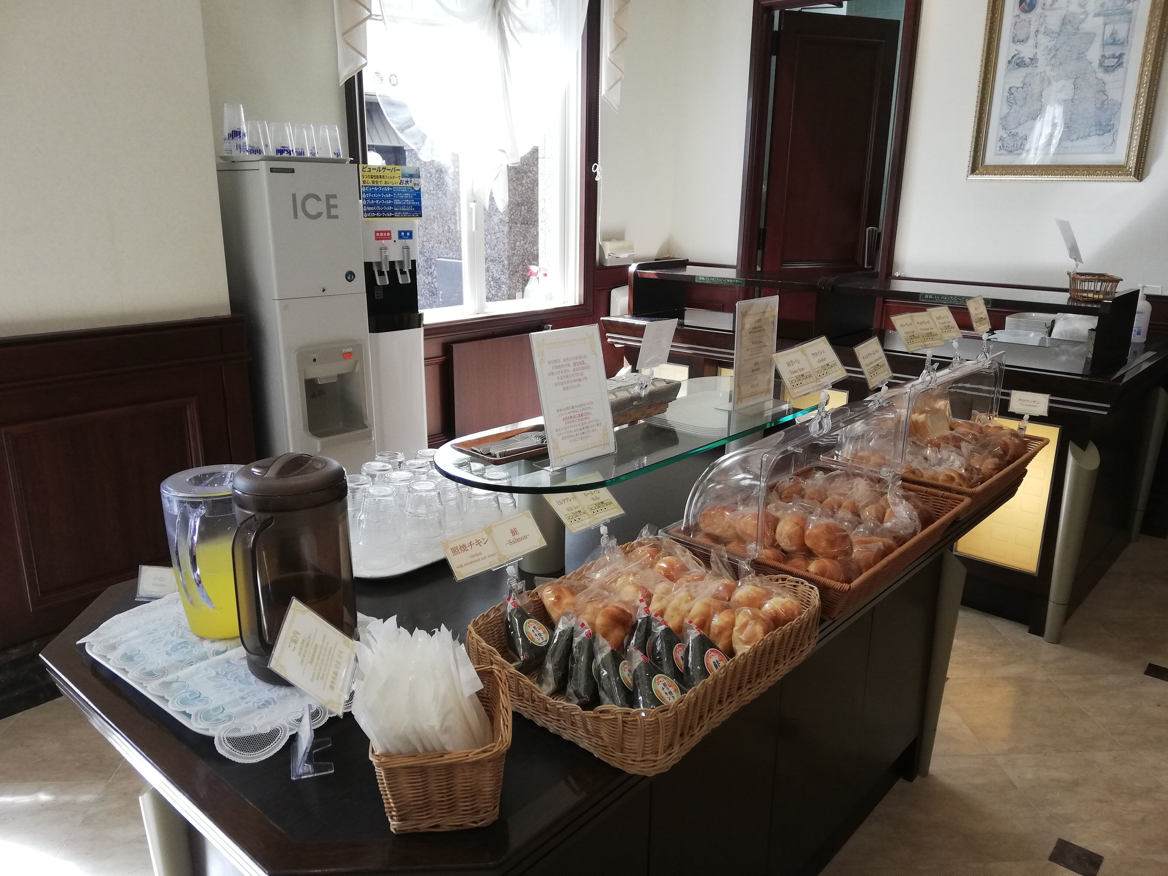 Ein Buffet mit verschiedenen Speisen, einer Kaffeemaschine und einem Kühlschrank.
