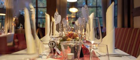 Une table à manger élégamment dressée, avec des bougies, des verres et un menu.