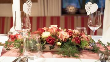 A table set with wine glasses, a floral centerpiece, and cutlery.