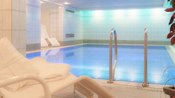 Een binnenzwembad en ligstoelen
