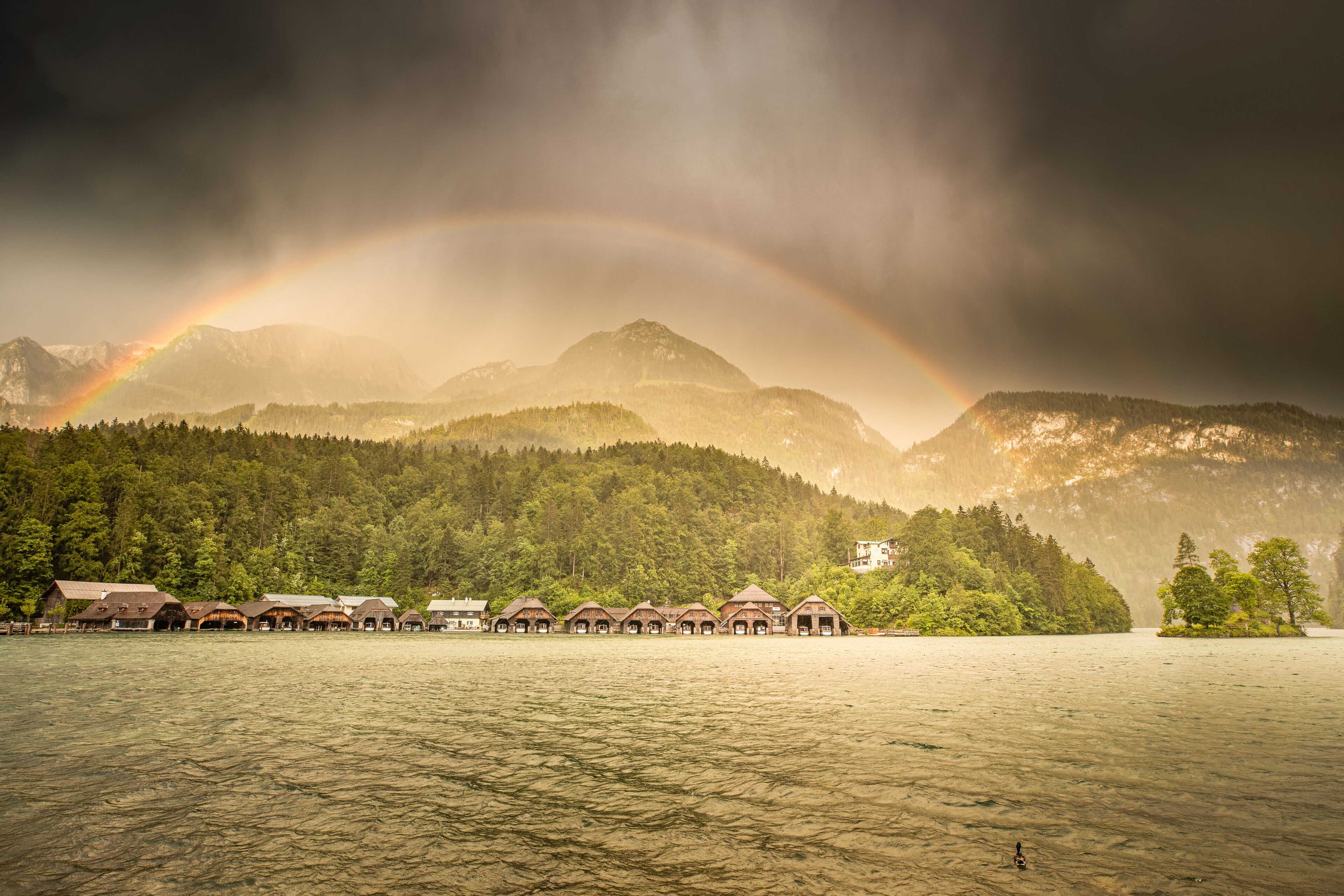 A lakeside resort with multiple cabins and a mountain backdrop.