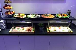 A buffet with various food items including fruits, vegetables, and meats. - Wincent Hotel (Sinsheim)