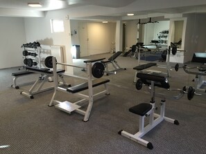 A gym with various exercise equipment, including weight machines and free weights.