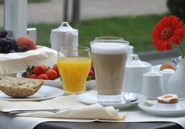 A breakfast setting with a glass of orange juice, a tall glass of milk, a slice of toast, and a small plate with a fried egg. - R&R Strandhotel Baabe (Ostseebad Baabe)