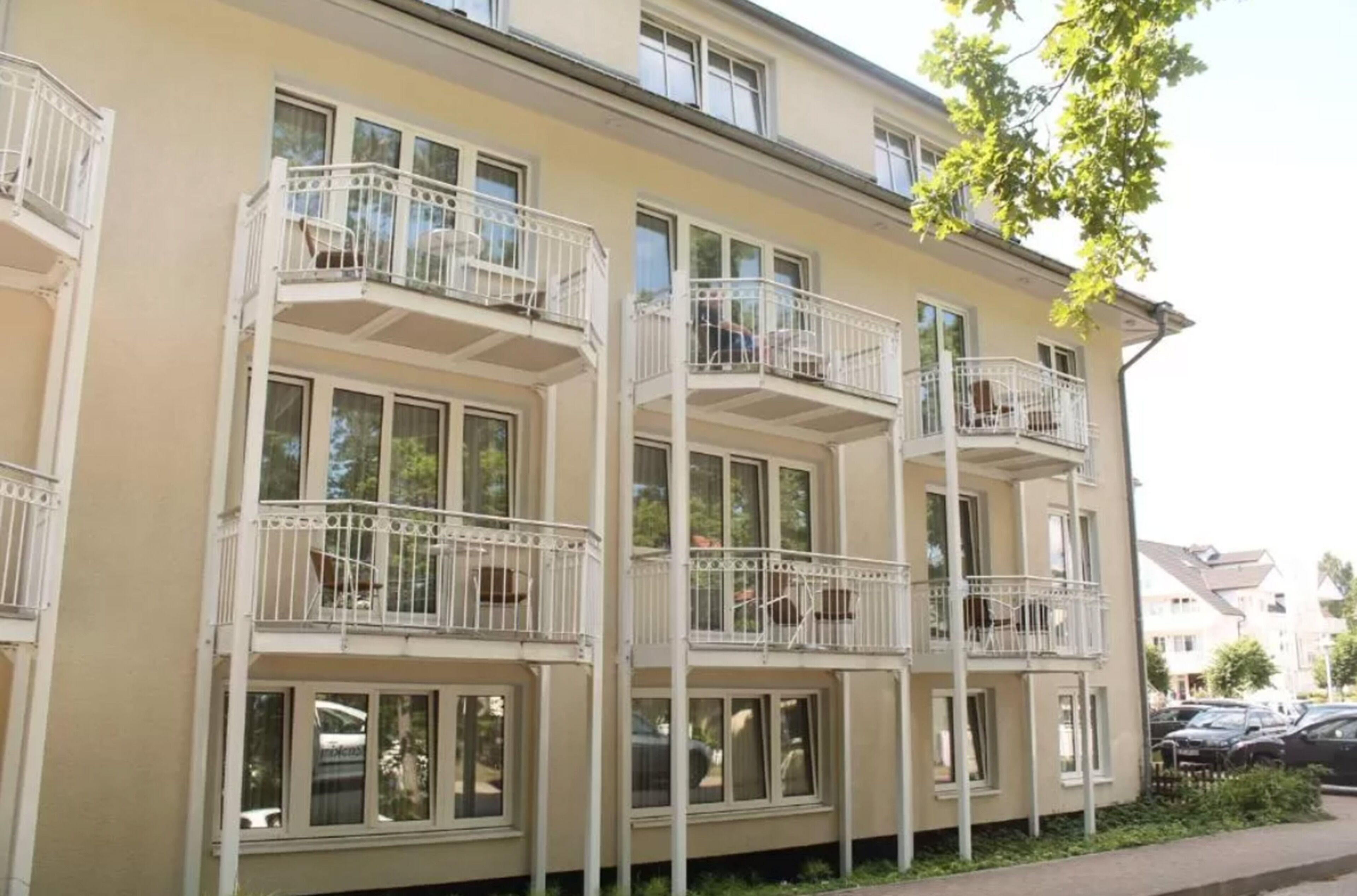 A multi-story residential building with balconies and large windows.