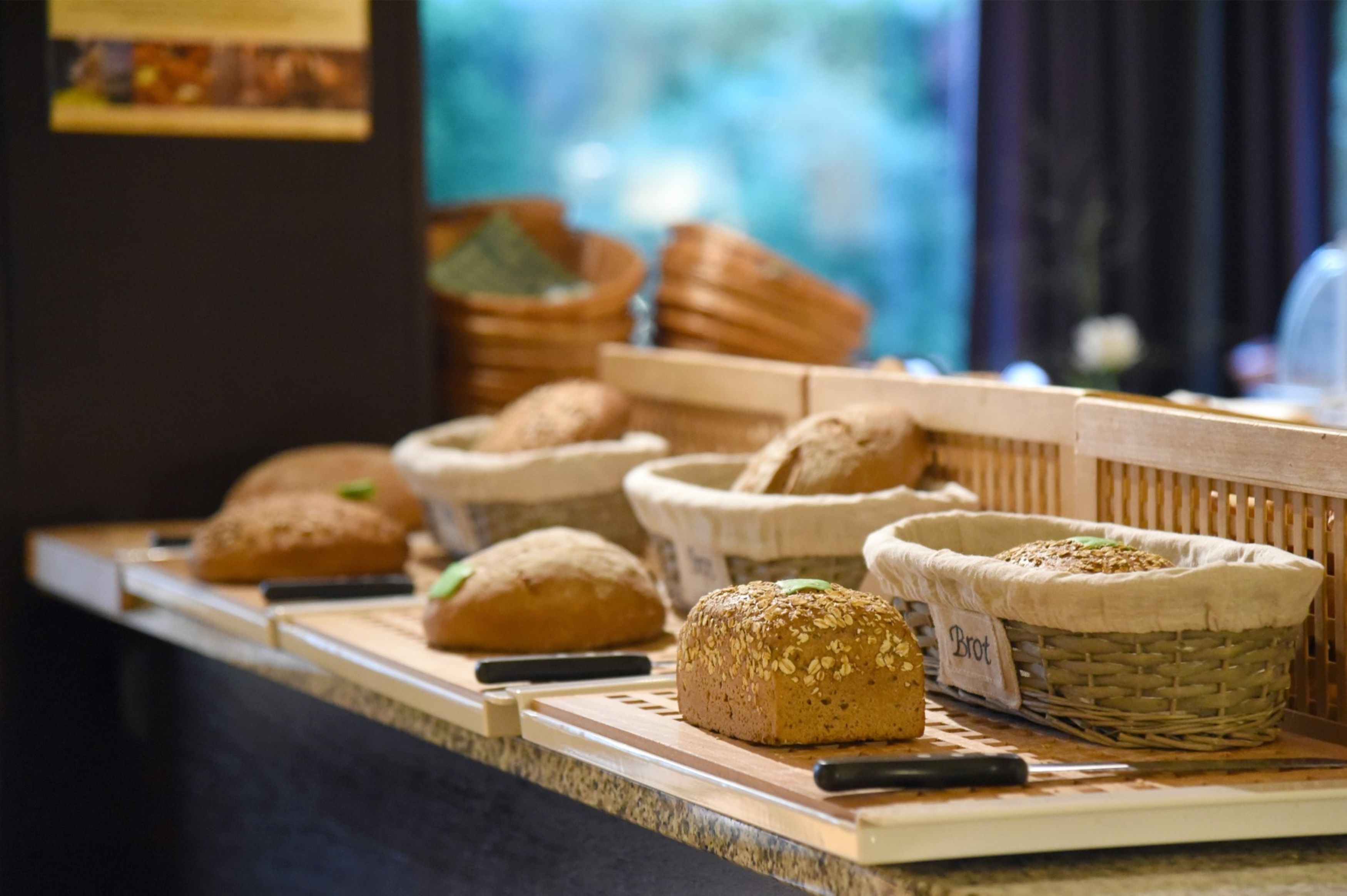 A bakery display with various types of bread in baskets.
