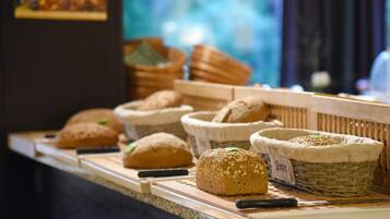 A bakery display with various types of bread in baskets.