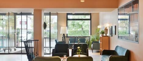 Un hall espacioso con zona de estar, ventanas amplias y vistas al exterior.