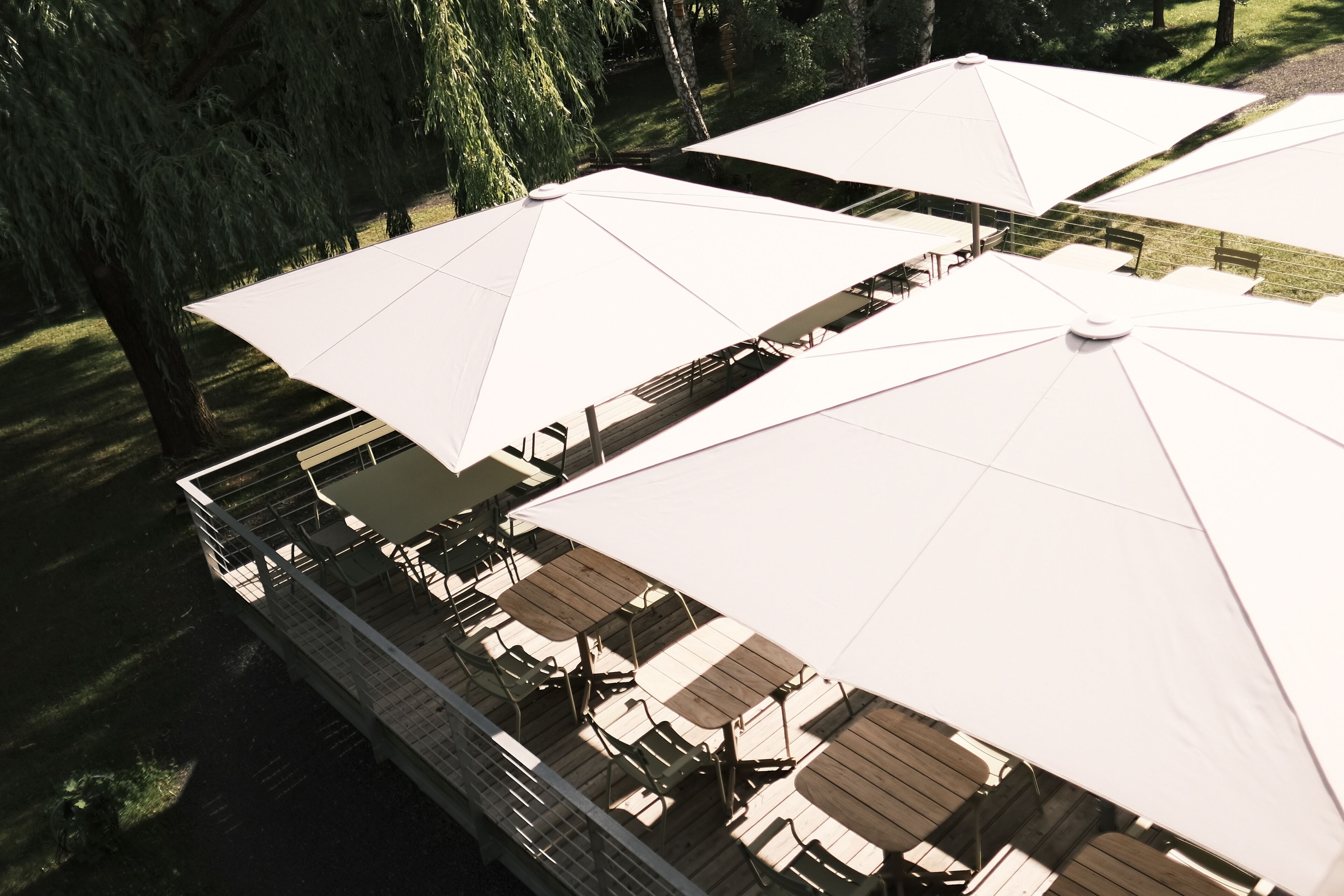 A deck with outdoor seating and umbrellas.