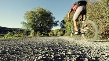Un camino de grava con un ciclista en movimiento.
