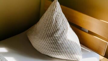A pillow on a bed with a wooden headboard.