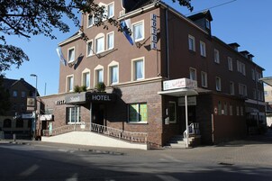Um hotel com uma placa indicando ser um 'HOTEL' e o restaurante 'Barbels'.