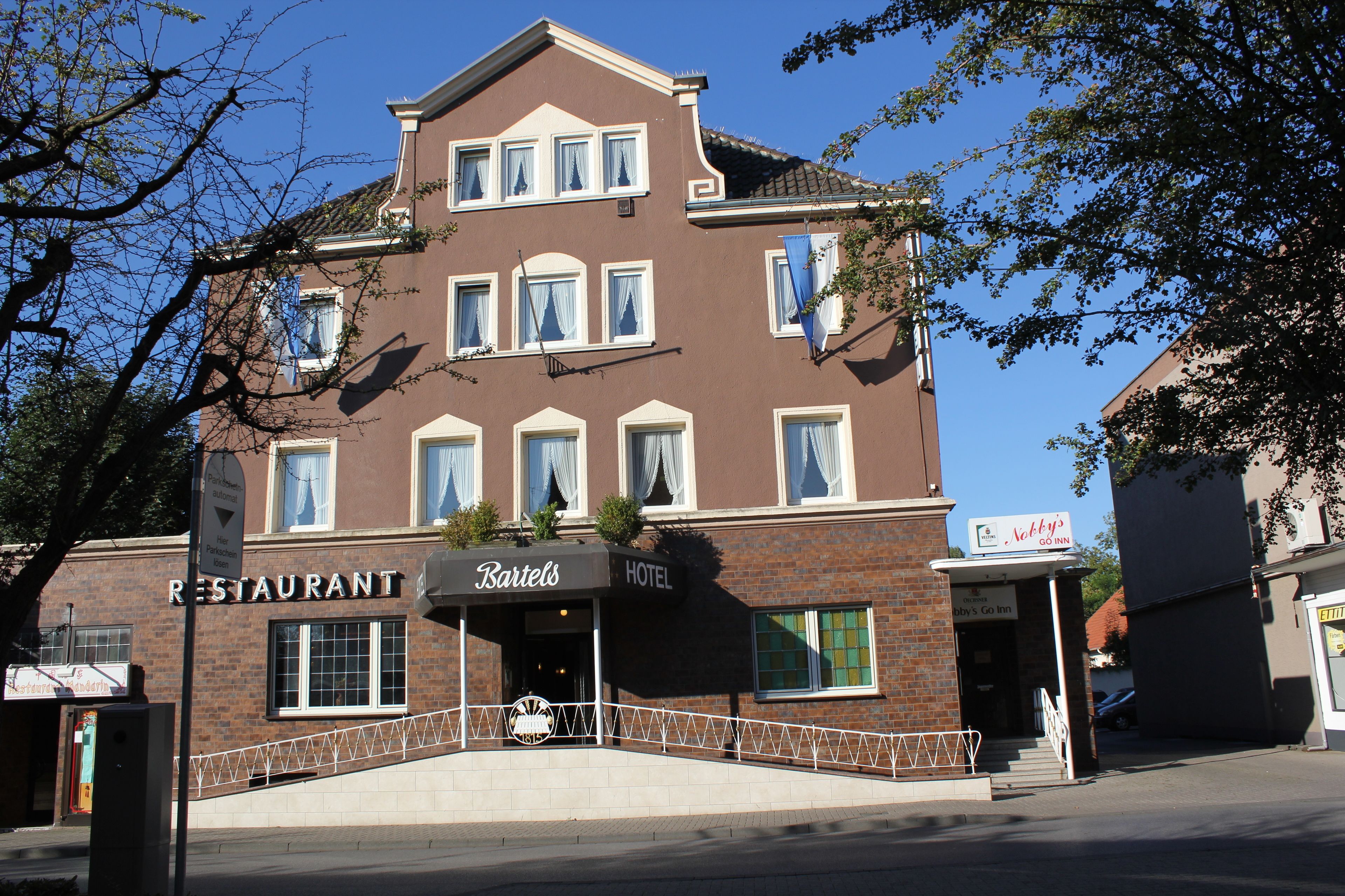A two-story building with a sign for 'Bartels' restaurant and 'Hotel'.