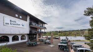 A hotel with outdoor seating and a view of a lake.
