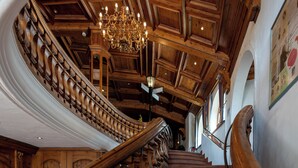 A grand staircase with ornate railings and a chandelier.