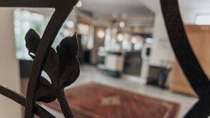 A view through a doorway with a metal railing, leading to a room with a red carpet and a blurred background. - Avantgarde Hotel (Hattingen)