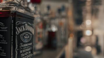 Primer plano de una botella de whisky Jack Daniel's con un fondo desenfocado de otras botellas.
