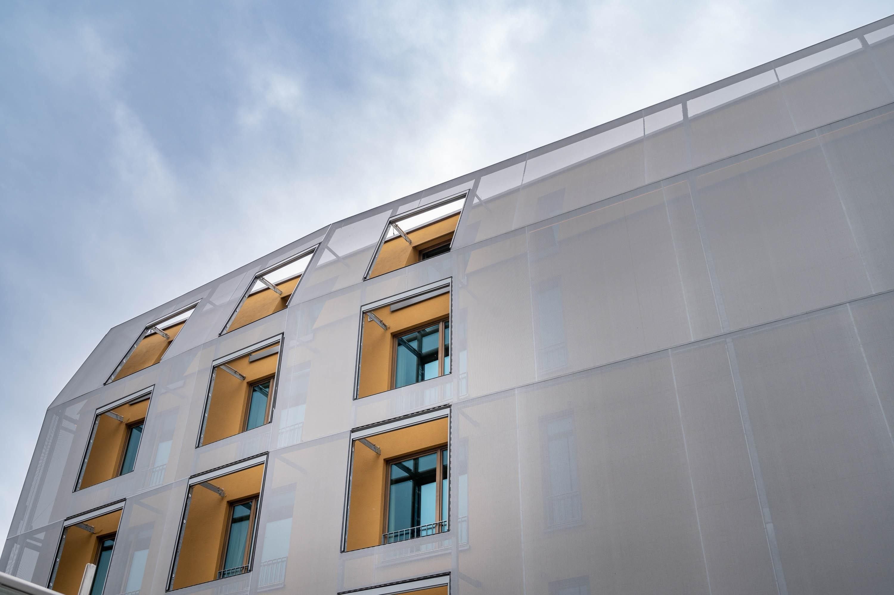 Un edificio moderno con varias ventanas y balcones.