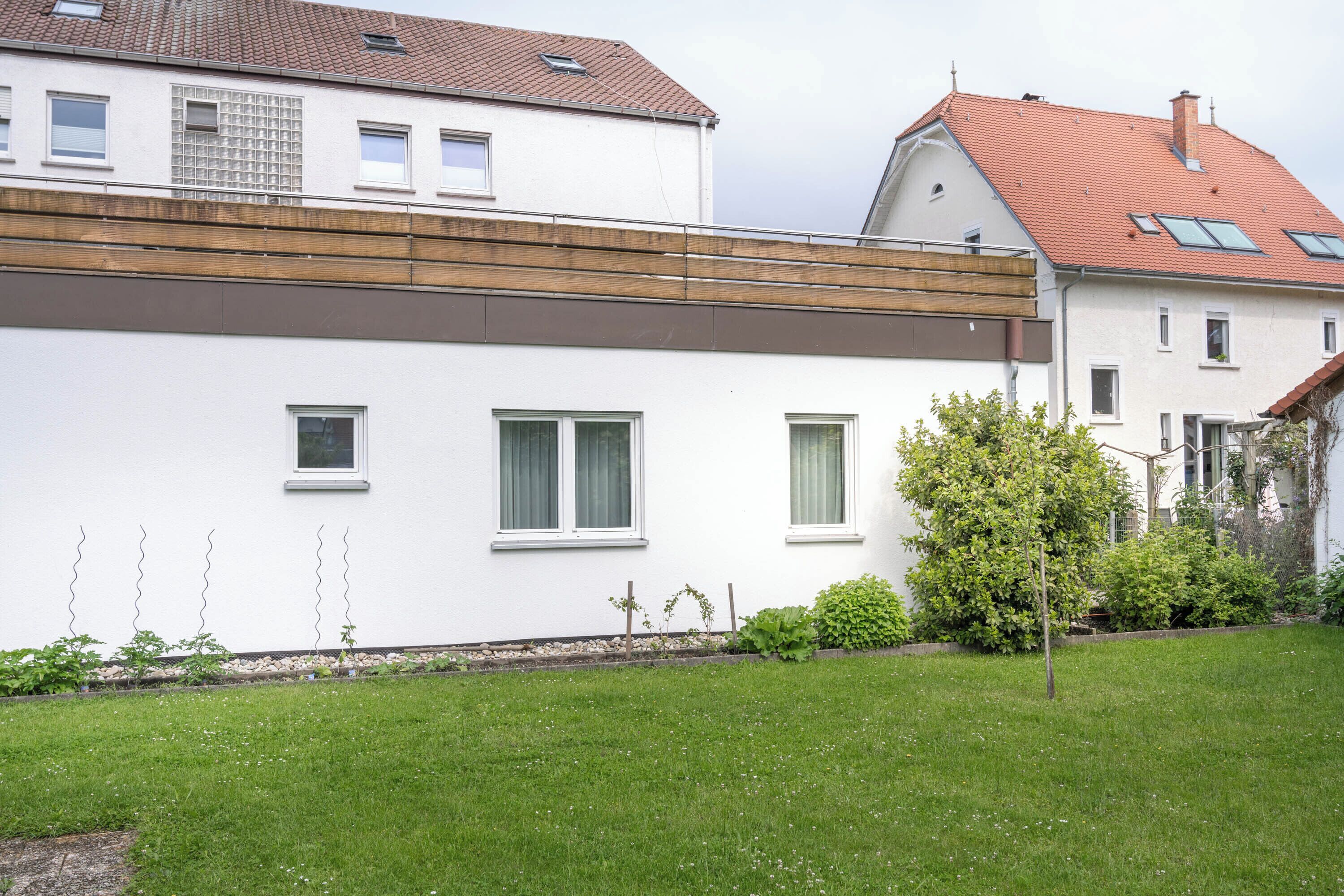 A modern two-story house with a flat roof and white exterior walls.