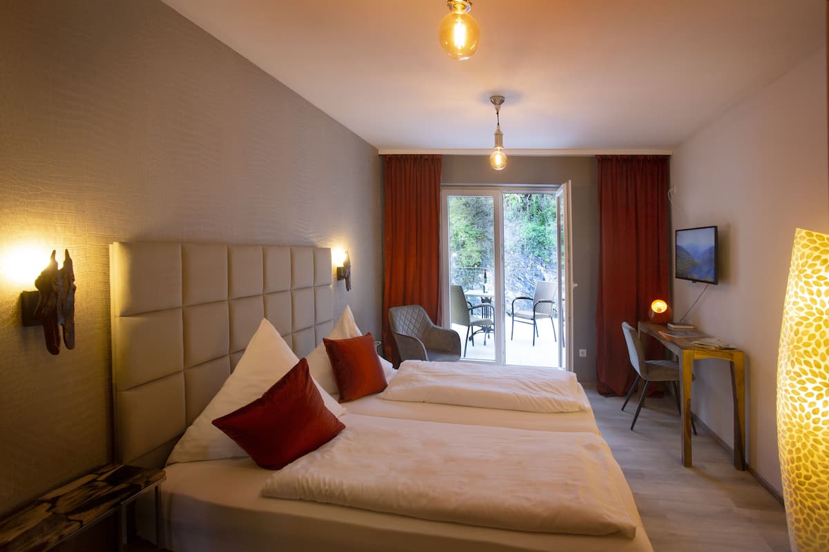 A hotel room with a large bed, a desk, and a view of the outdoors.