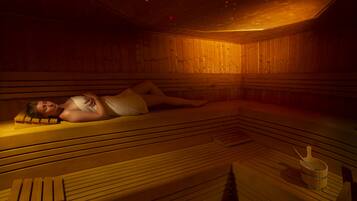 A sauna with wooden benches and a bucket.