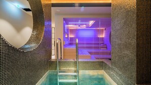 A modern indoor pool area with a glass wall, metal stairs, and a tiled floor. - Zeller Hotel & Restaurant (Kahl)