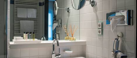 A modern bathroom with a white sink, a mirror, and a towel rack.