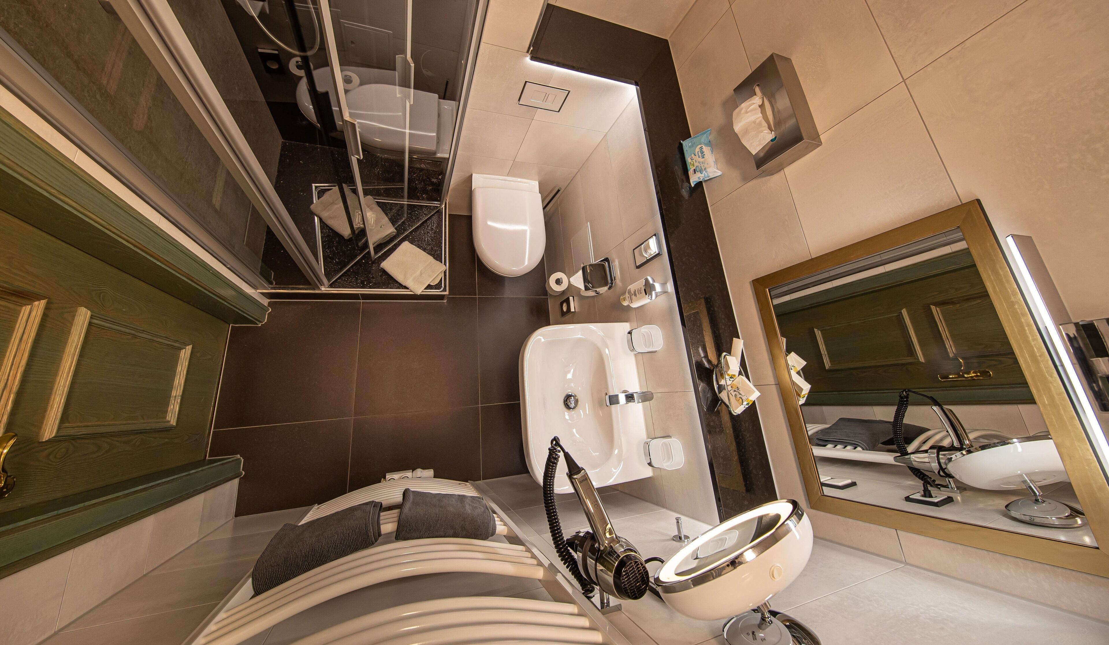 Un baño moderno con bañera, un espejo grande y un inodoro.