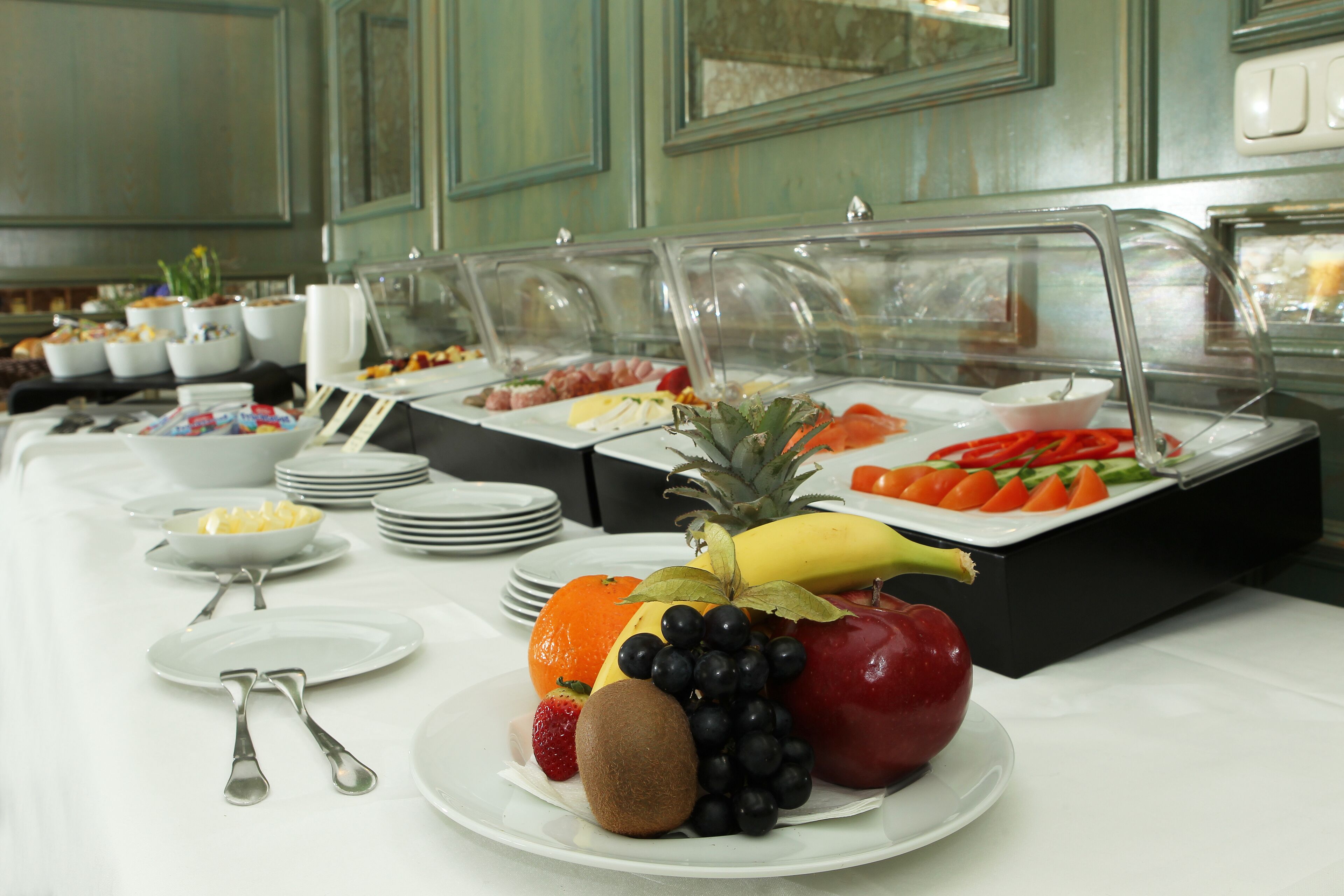 Ein reichhaltiges Buffet mit verschiedenen Früchten und Gemüsesorten, darunter Äpfel, Bananen und Orangen.