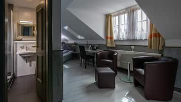 A modern, compact living space with a kitchenette, a dining area with a table and chairs, and a large window with curtains.