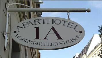Señalización de 'Aparthotel 1A' con el nombre 'Robert Müller-Strasse'.