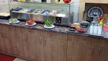 Ein Bereich mit einem Buffet und verschiedenen Speisen sowie Beilagen.