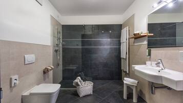 Une salle de bain moderne équipée de toilettes, d’un bidet, d’une douche et d’un lavabo.