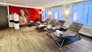 A modern waiting area with lounge chairs, a large mural, and a view of the outdoors. - Regiohotel Naturresort Ilsenburg  (Ilsenburg)