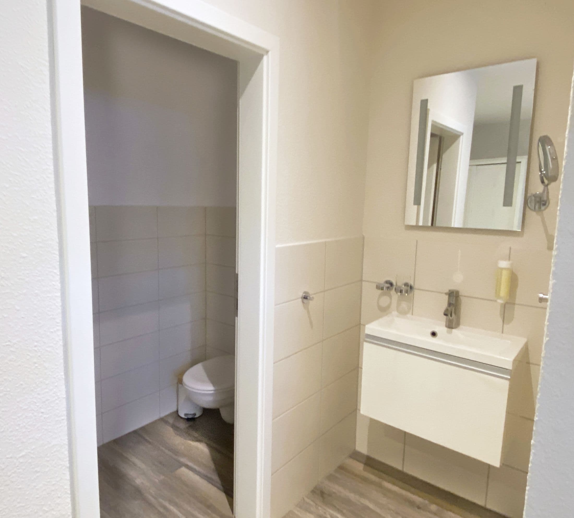 Un baño pequeño con inodoro, lavabo y espejo.