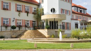A multi-story building with a central courtyard, stone steps, and a fountain. - Regiohotel Naturresort Ilsenburg  (Ilsenburg)