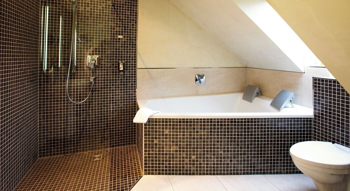 Un baño moderno con ducha, bañera y retrete.
