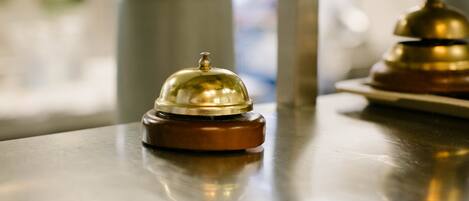 A polished metal table with two brass bell pushers.