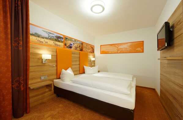A hotel room with a bed, wooden headboard, wall-mounted TV, and artwork depicting wildlife. - Hotel Gasthof Zur Post (Leipheim)