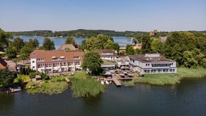 A lakeside hotel with multiple buildings, a dock, and boats. - Hotel Der Seehof (Ratzeburg)