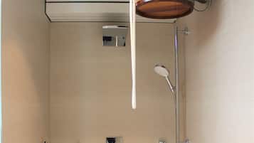 Eine Dusche mit Holzeimer, Duschbrause und Duschschlauch.