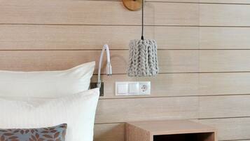 A bedroom with a wooden headboard, a bedside table with a lamp, and a nightstand with a book.